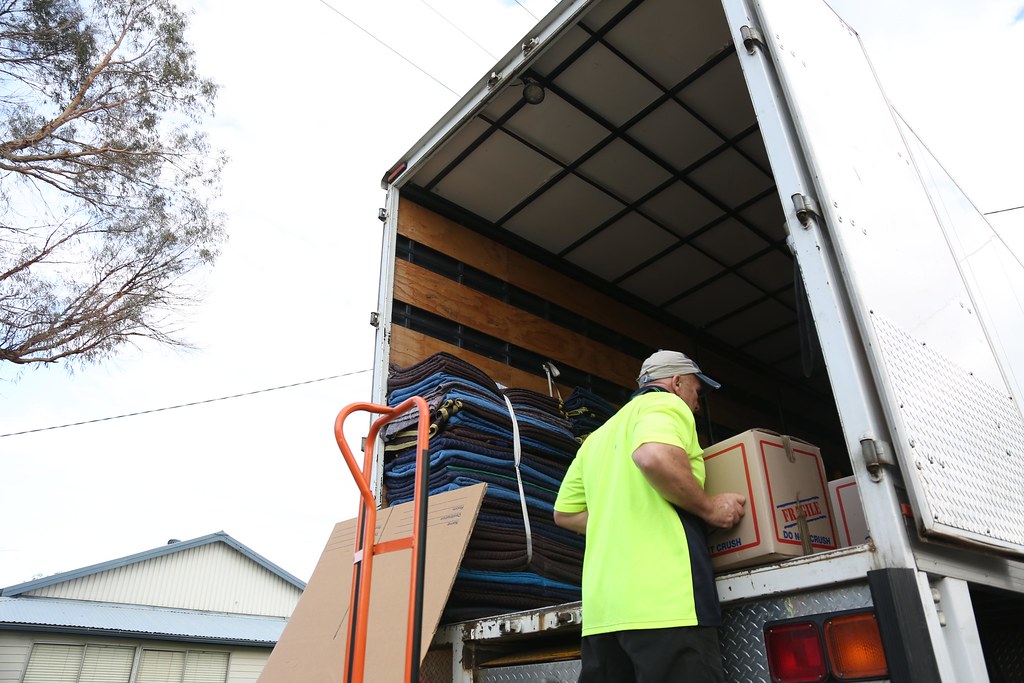 A mover loading the removal truck with boxes photo | Flickr